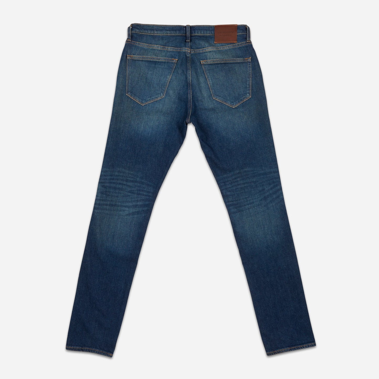 back of fully extended pair of men's athletic taper blue jeans with slight wear