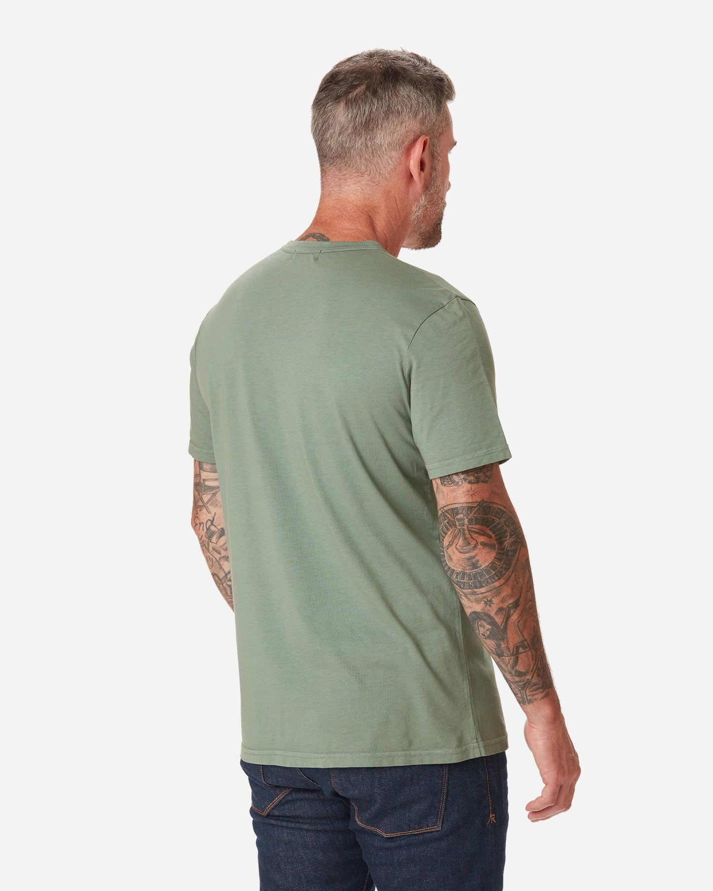 back of model facing away with a rightward gaze wearing Ace Rivington seafoam "sage" light green long staple cotton super soft supima cotton shirt