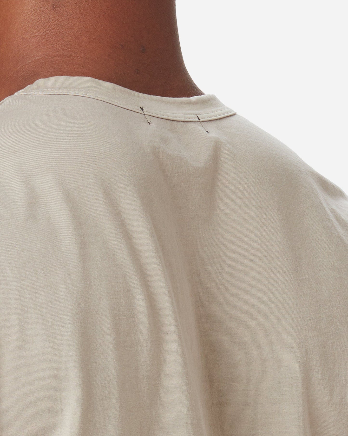 close up of back of model's neck wearing Ace Rivington long staple light beige sand coloredsuper soft short-sleeved cotton shirt