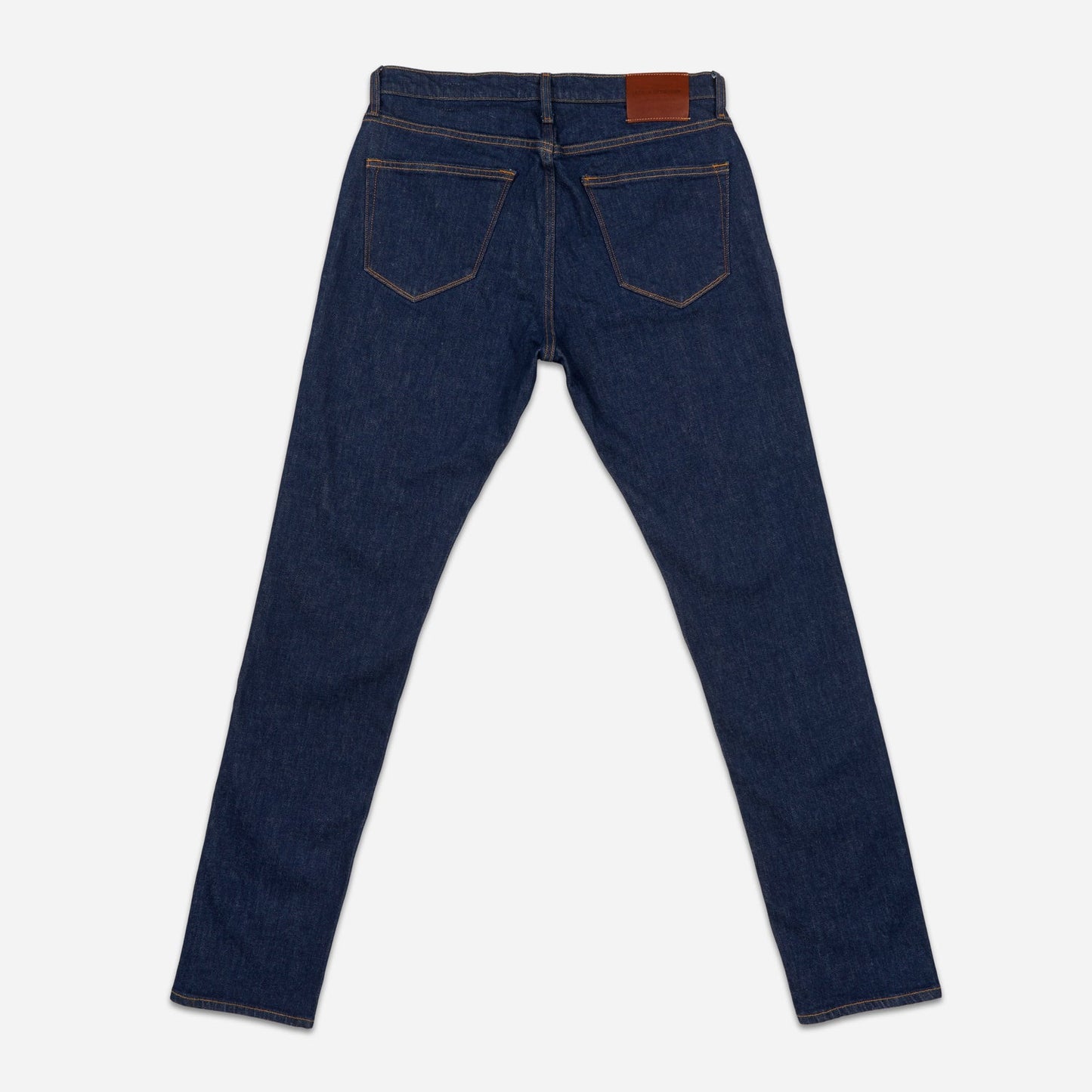 of pair of dark blue men's athletic taper jeans with no wear and legs fully extended