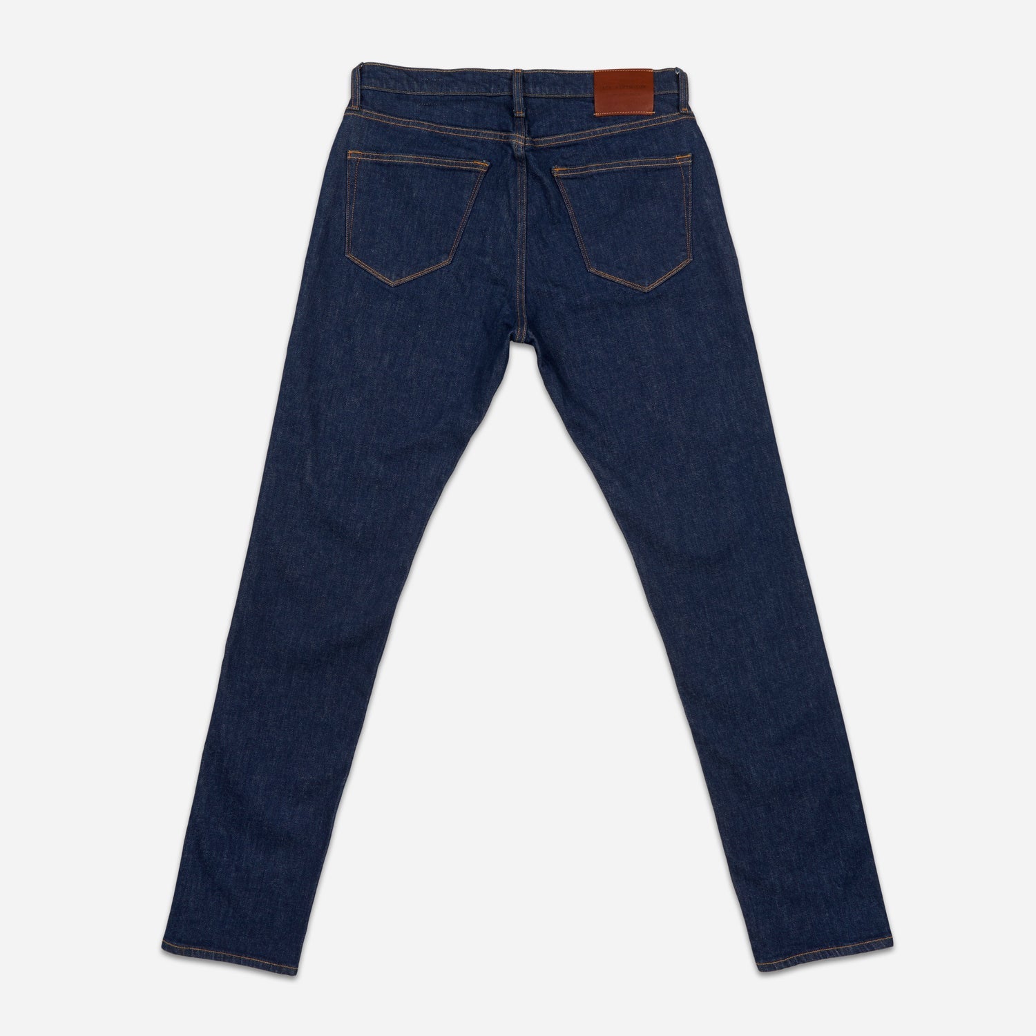 of pair of dark blue men's athletic taper jeans with no wear and legs fully extended