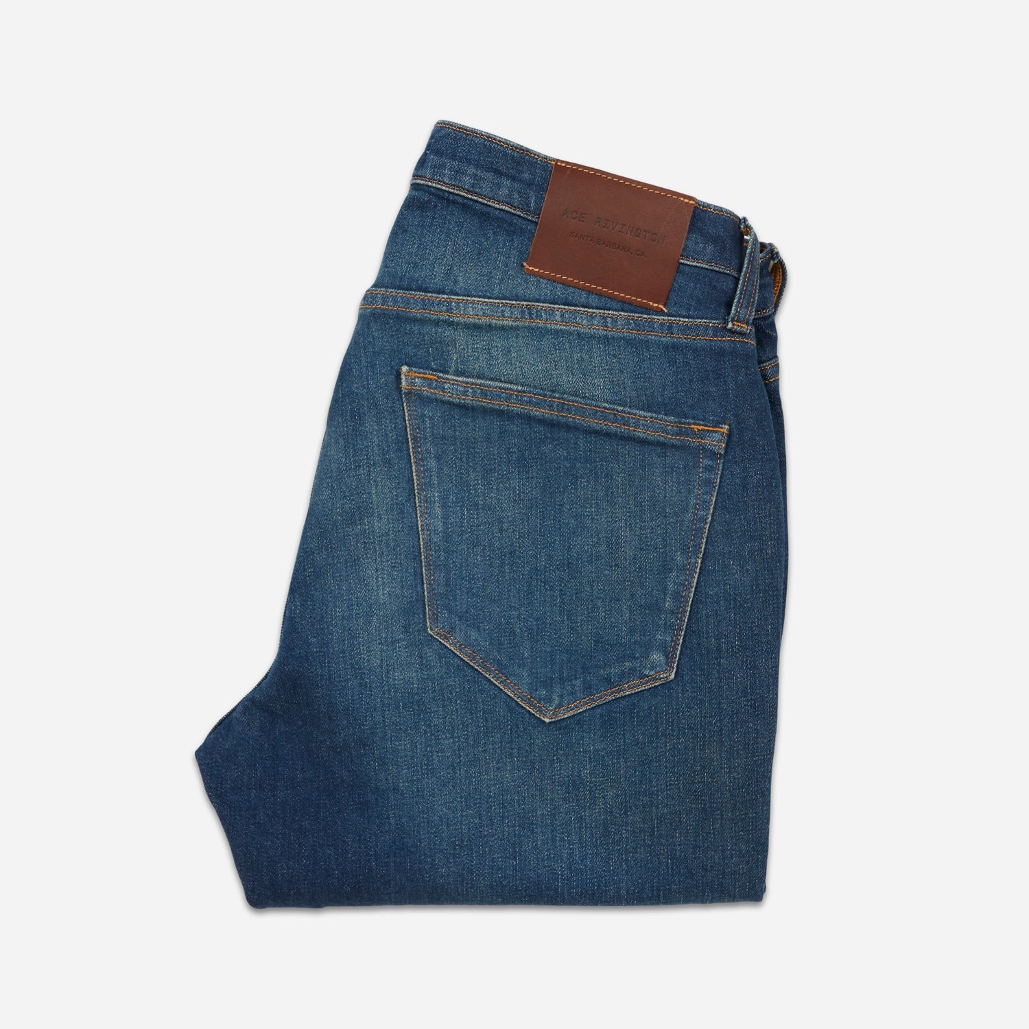 back of folded pair of men's athletic taper blue jeans with slight wear 