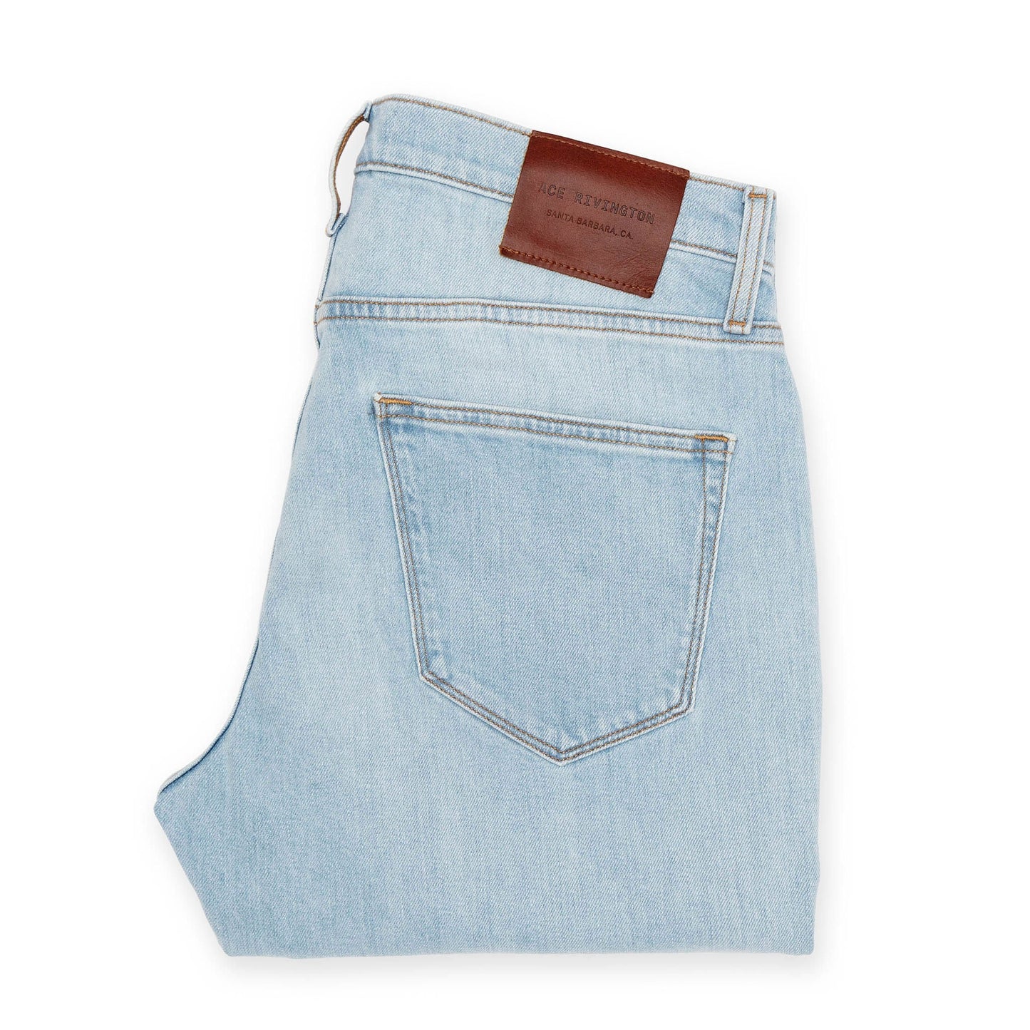 back of folded super light Ace Rivington jeans with gold stitching and antique brass and nickel detailing and brown leather logo branded belt loop patch 
