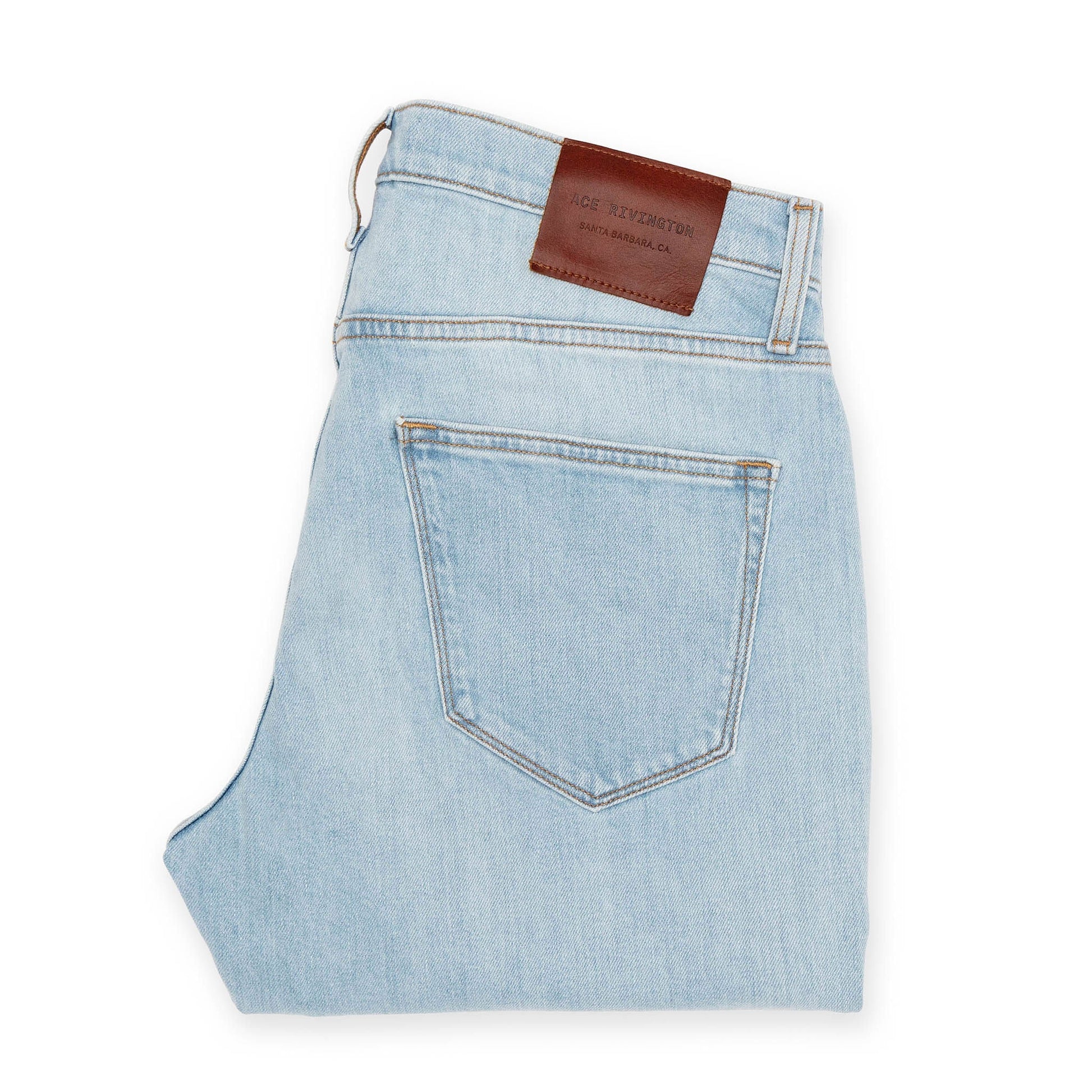 back of folded super light Ace Rivington jeans with gold stitching and antique brass and nickel detailing and brown leather logo branded belt loop patch 