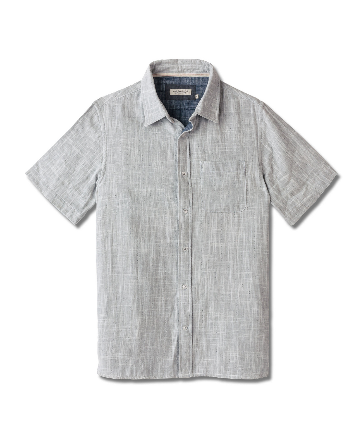 Front of full-view flat lay of Ace Rivington collared grey short-sleeved double gauze soft-textured cotton shirt with indigo blue interior, pearl buttons, and left-breast pocket