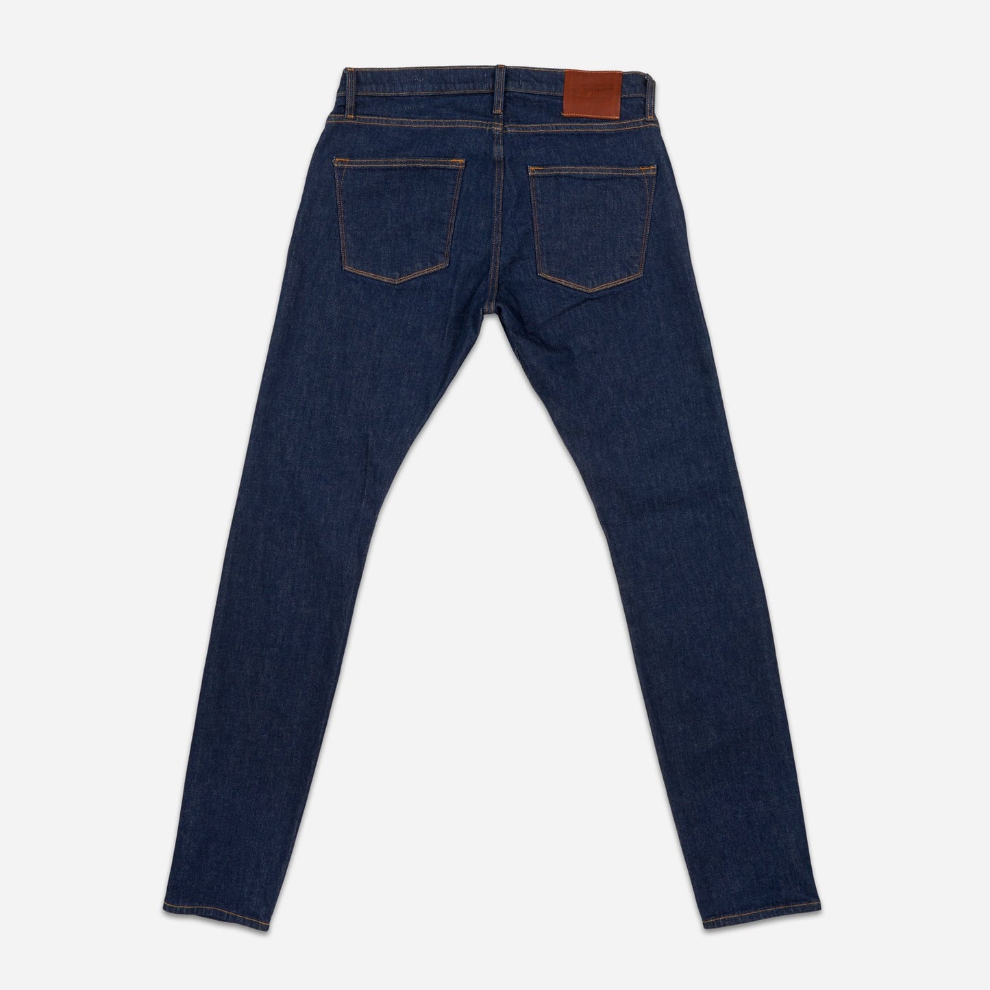 back of fully extended pair of high quality slim cut men's dark blue jeans with no wear