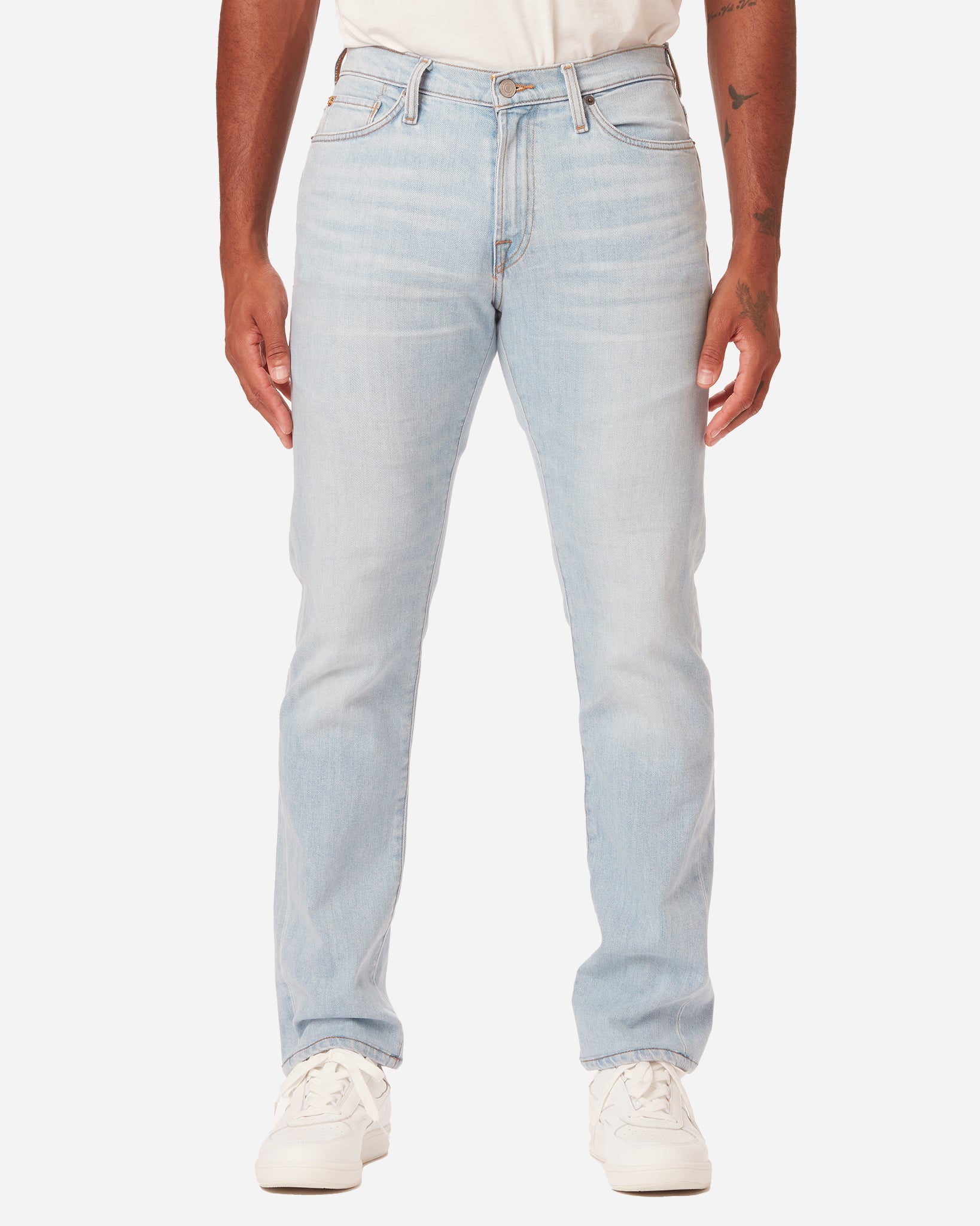 model facing directly forward wearing Ace Rivington super light blue denim jeans with antique nickel detailing with a pair of white Diadora B Elite sneaker shoes and tucked white Ace Rivington super soft supima short-sleeved tee shirt